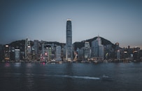 city skyline across body of water during night time