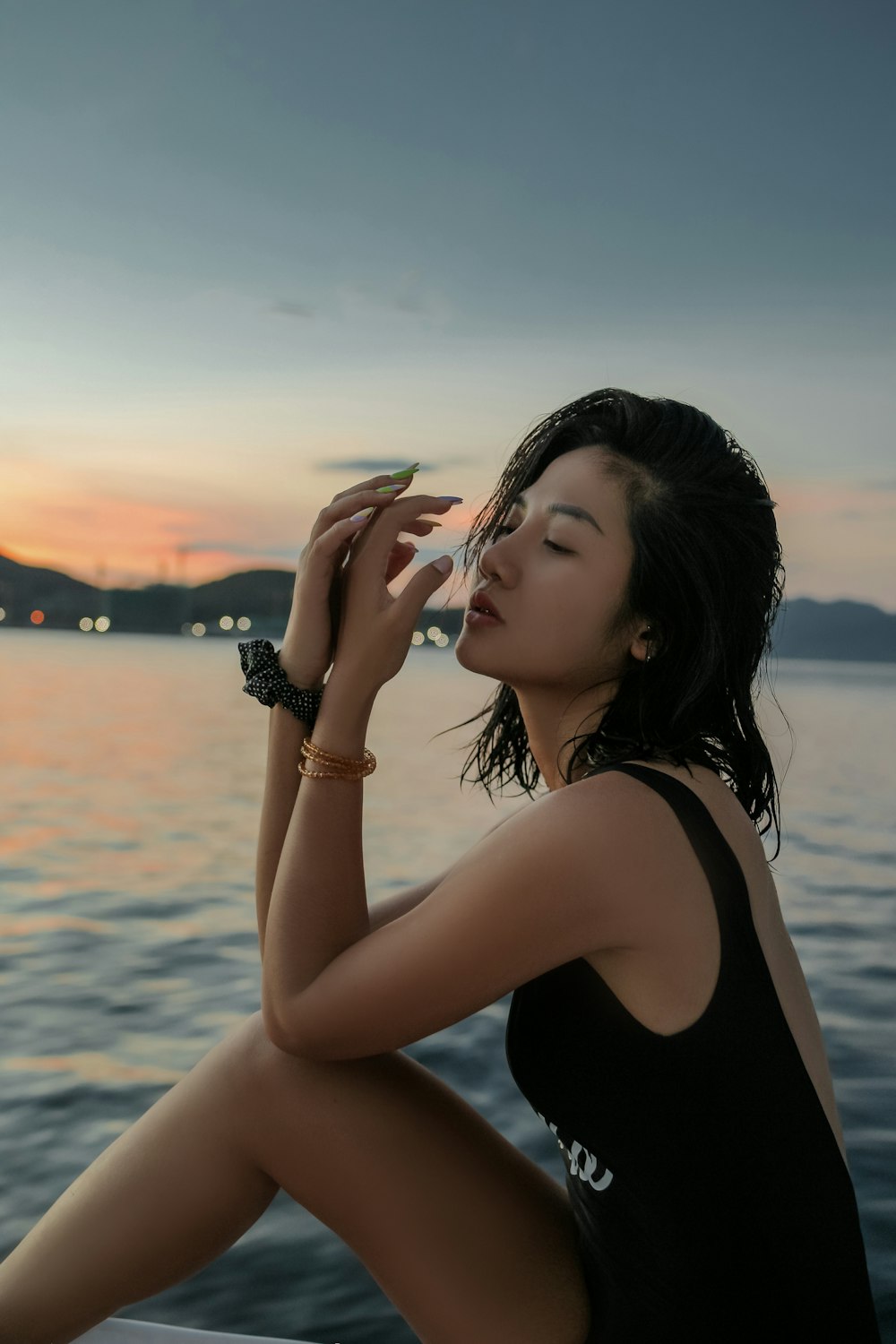 woman in black tank top standing near body of water during daytime