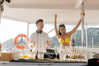 man in white dress shirt standing beside woman in yellow bikini top