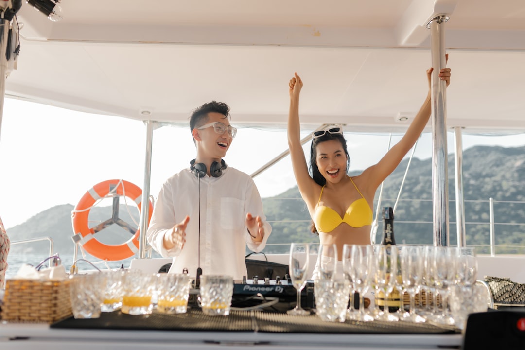 man in white dress shirt standing beside woman in yellow bikini top