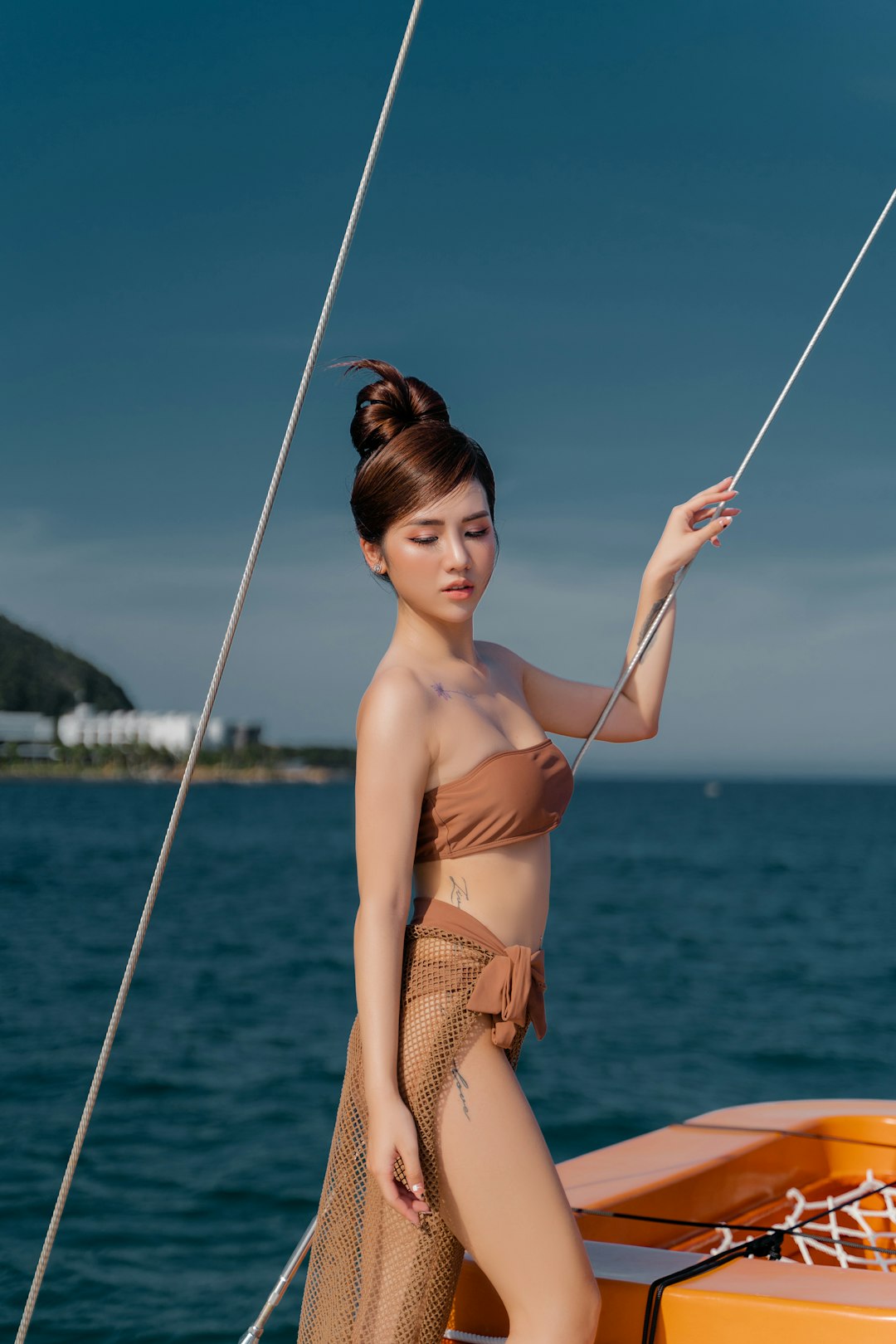 woman in brown bikini holding rope
