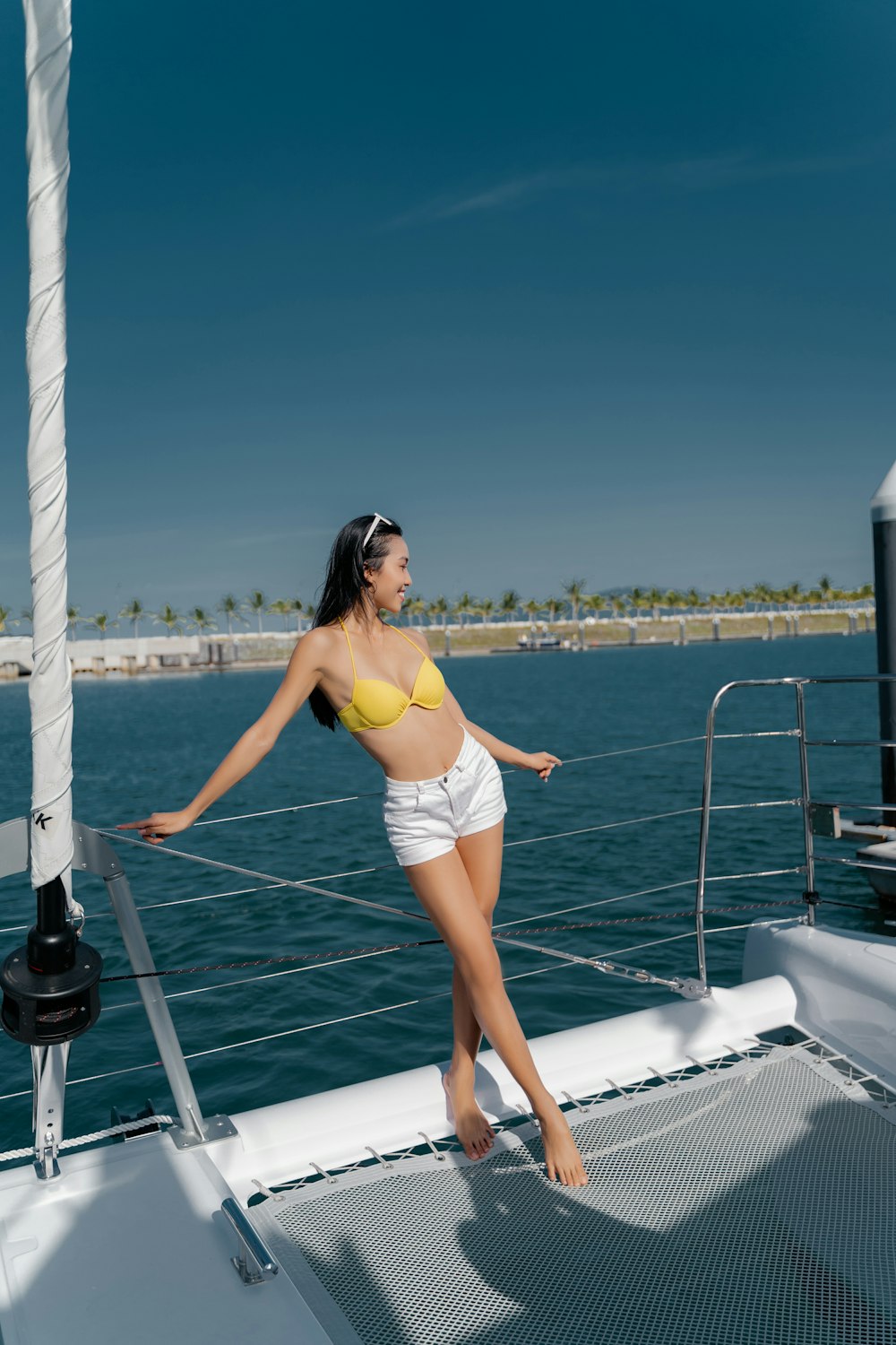 woman in yellow bikini standing on white boat during daytime