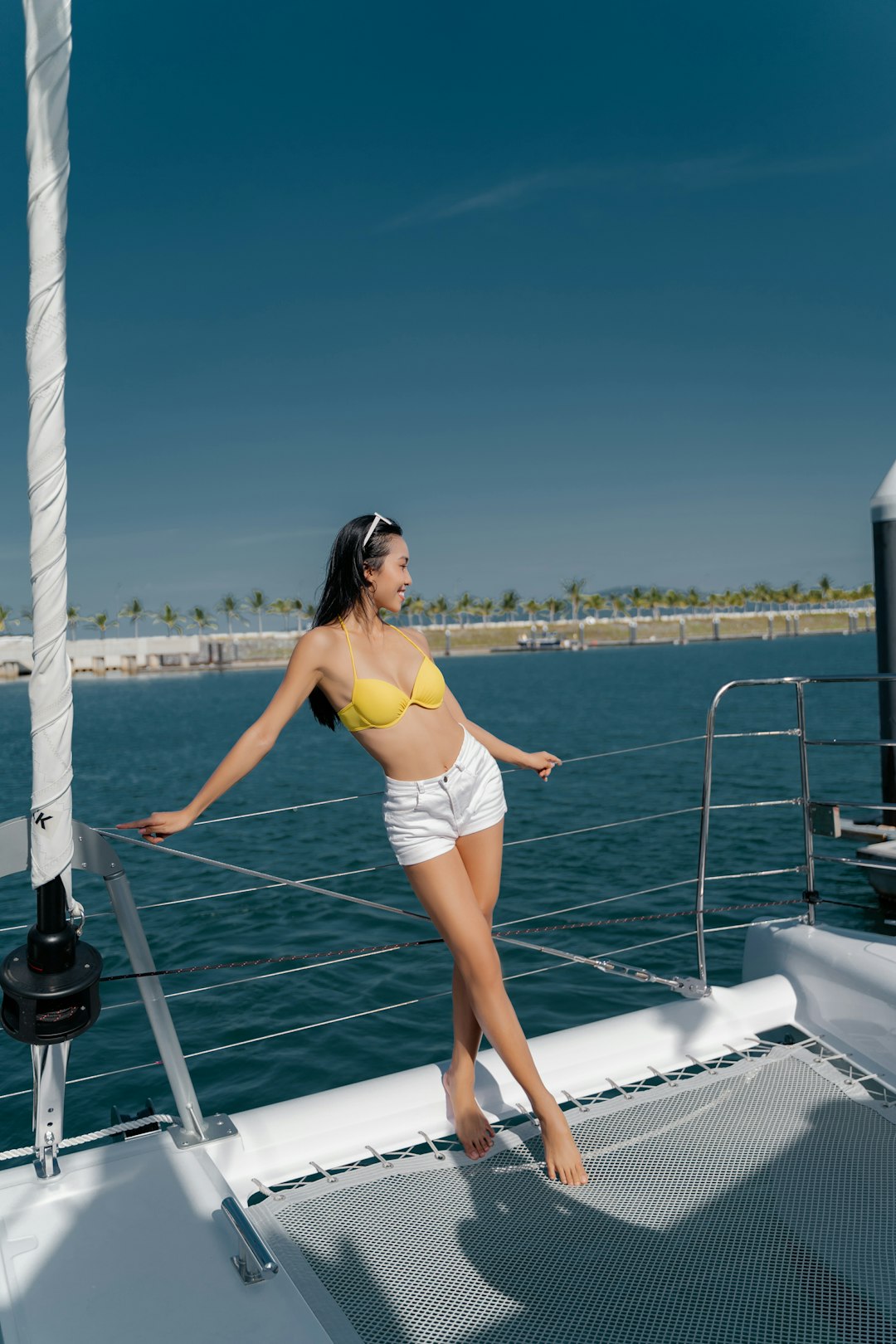 woman in yellow bikini standing on white boat during daytime