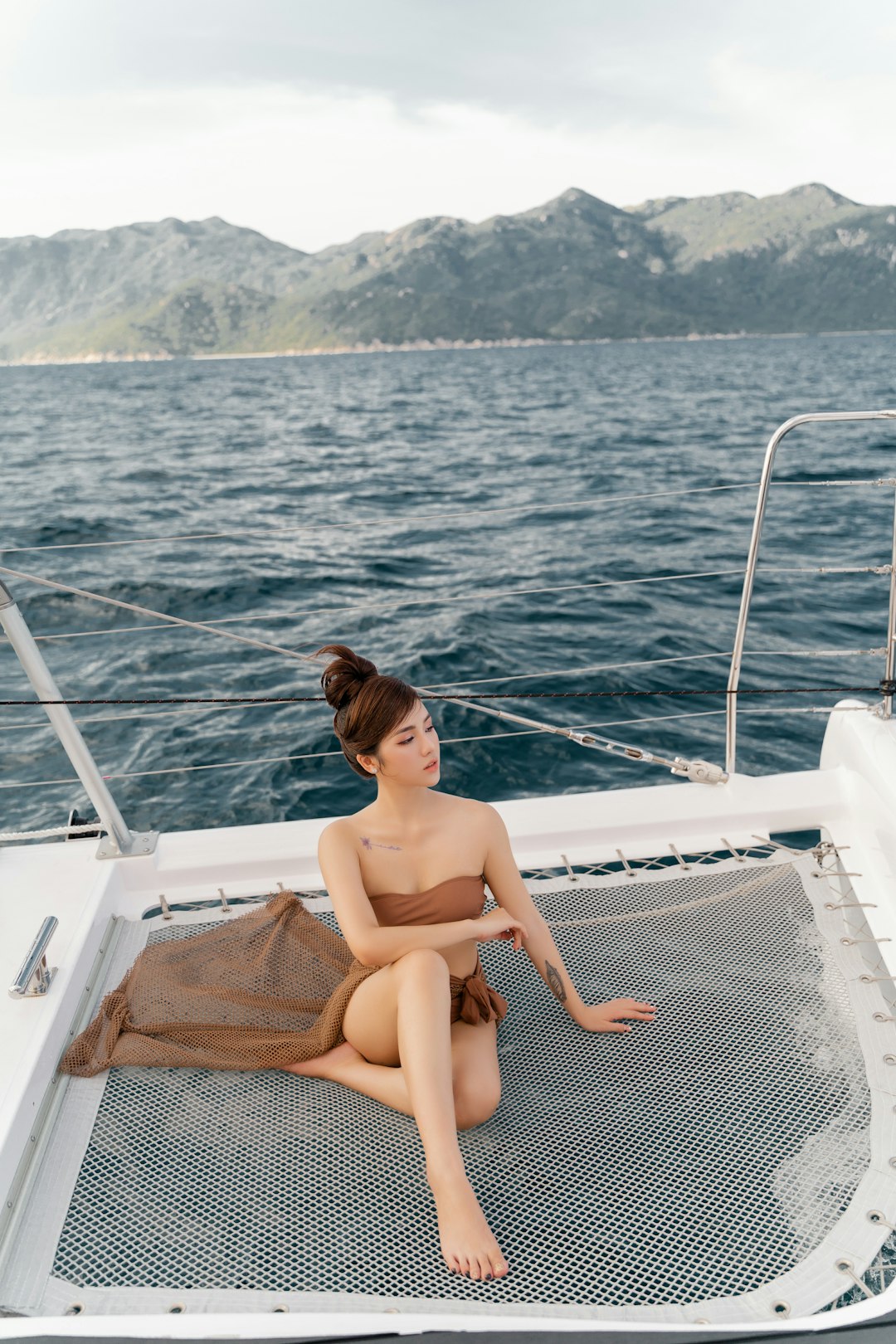 woman in black bikini sitting on white boat during daytime