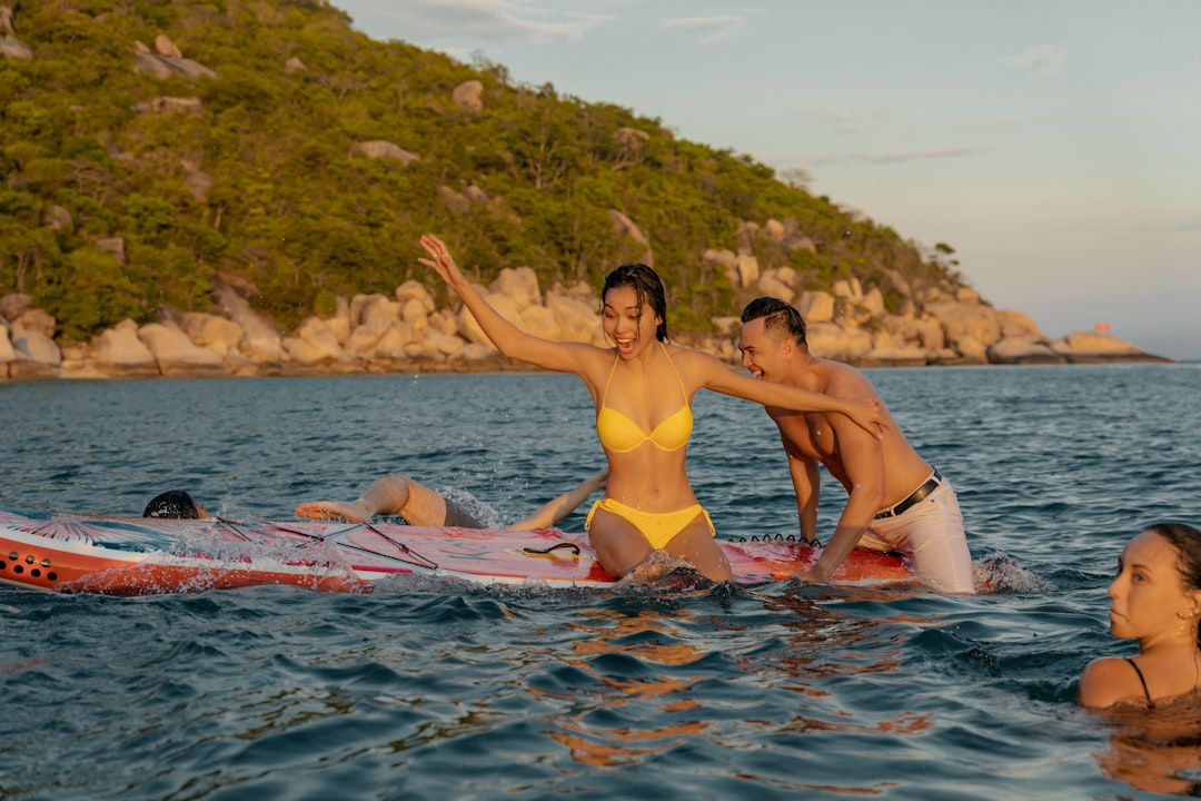 2 women in yellow bikini on water during daytime