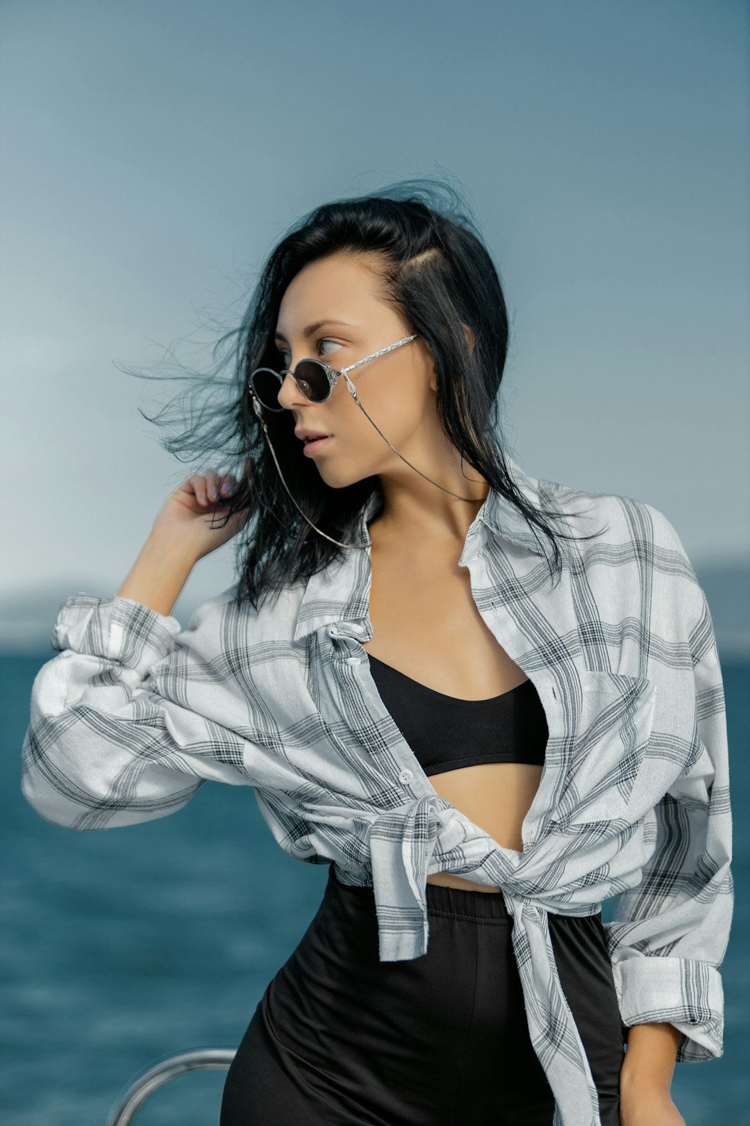 woman in black tank top and white and black plaid jacket wearing black sunglasses