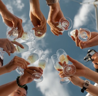 people holding clear glass bottles during daytime