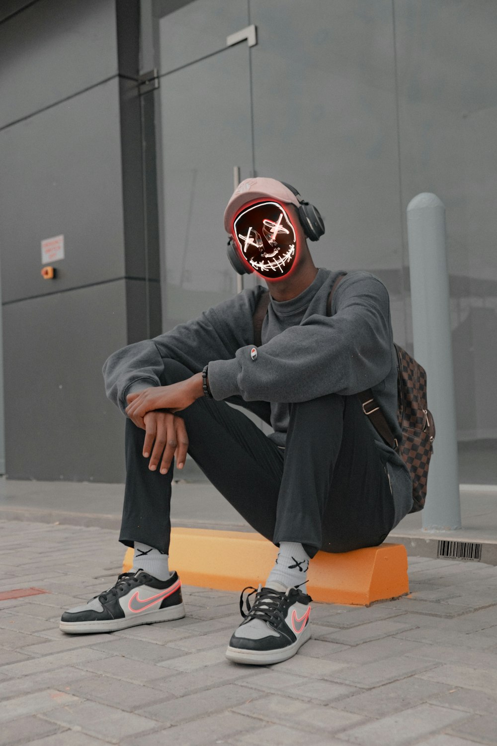 man in black jacket and orange helmet sitting on orange plastic seat