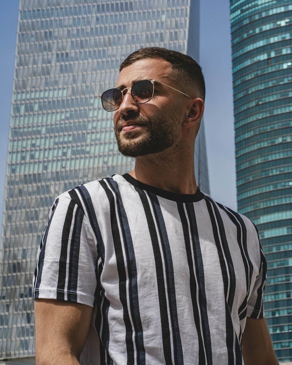 man in black and white striped crew neck t-shirt wearing black sunglasses