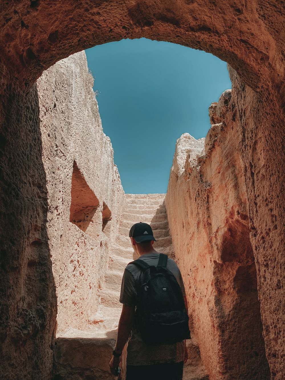 man in black jacket standing on brown rock formation during daytime