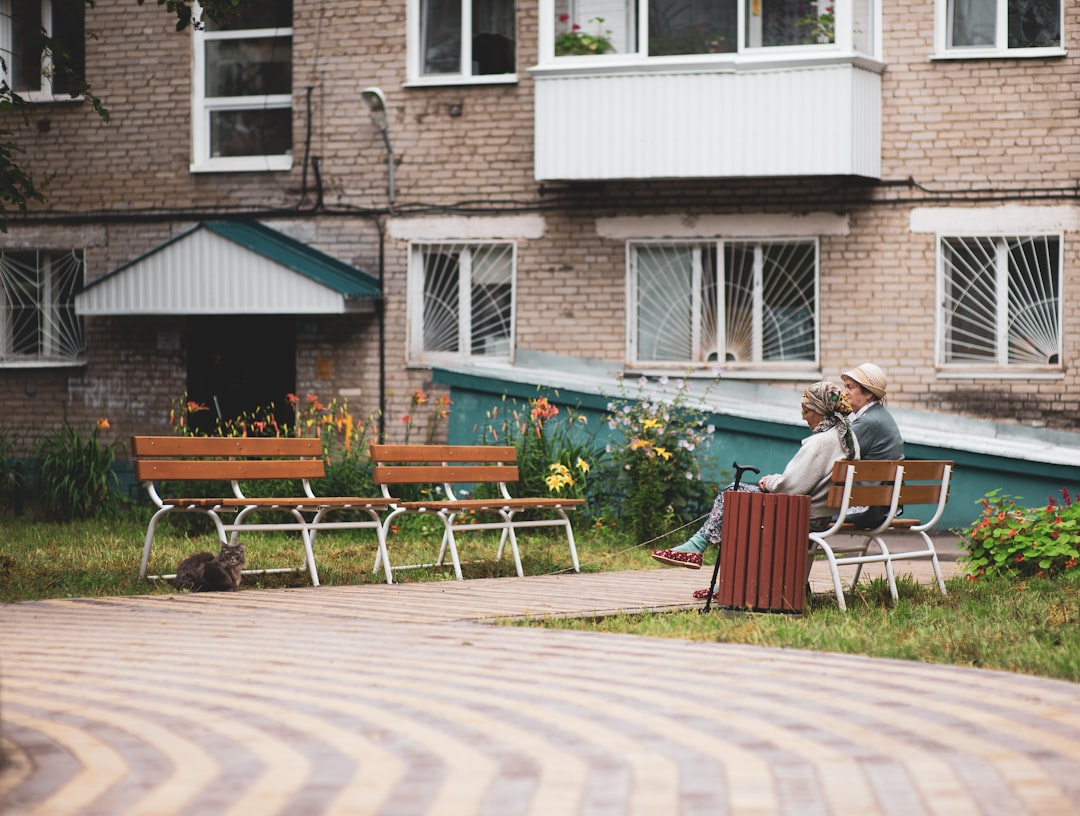 woman in black and white stripe shirt sitting on brown wooden bench during daytime