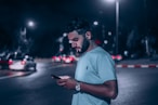 man in white polo shirt holding smartphone