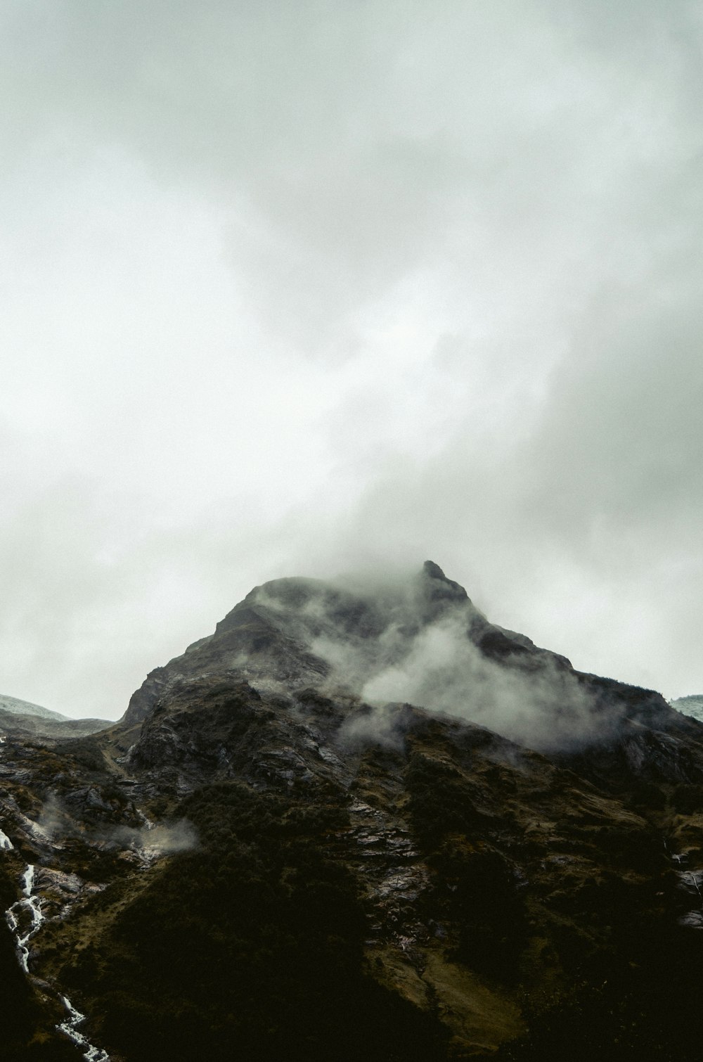 black and white mountain under white clouds