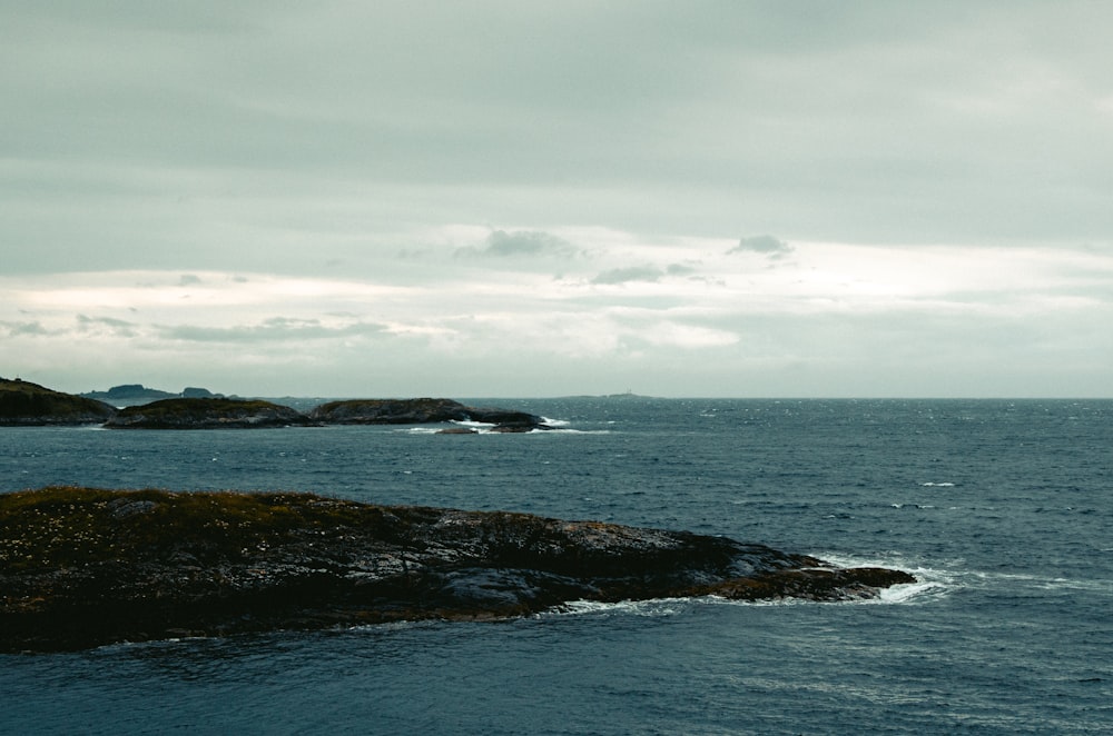 body of water under white clouds during daytime