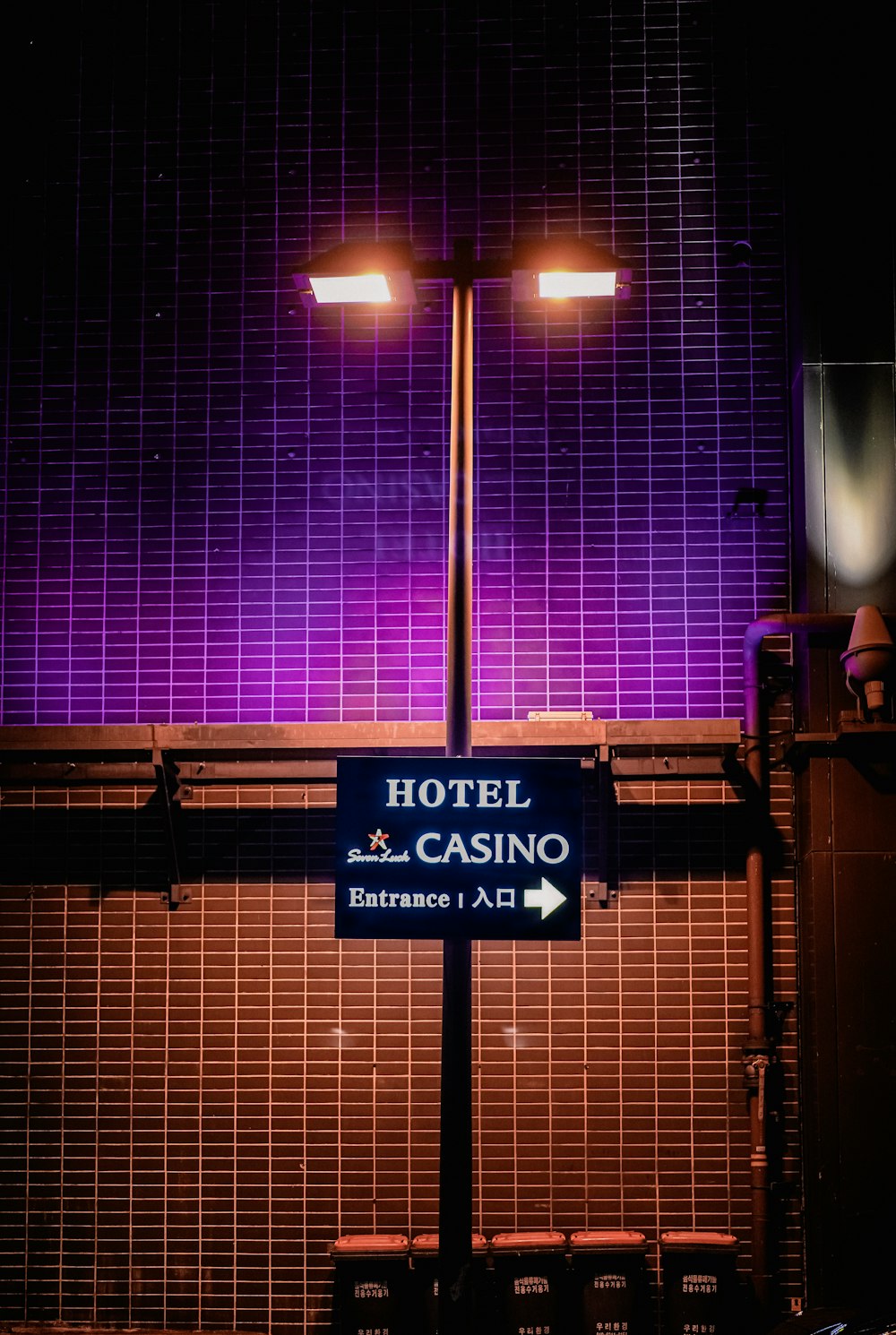 a hotel and casino sign in front of a purple wall