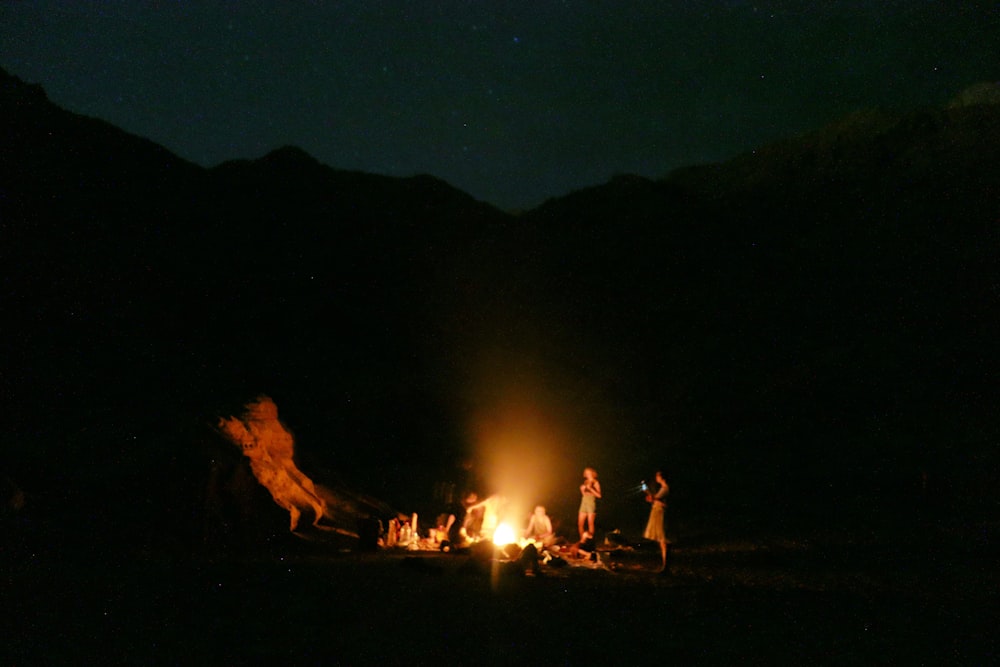 people standing near bonfire during night time