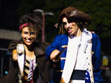 Two lively pirate characters engaging children with playful sword fights at a birthday party.
