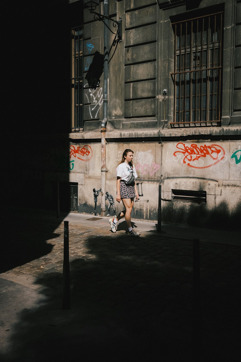 woman in white t-shirt and white shorts running on street during daytime