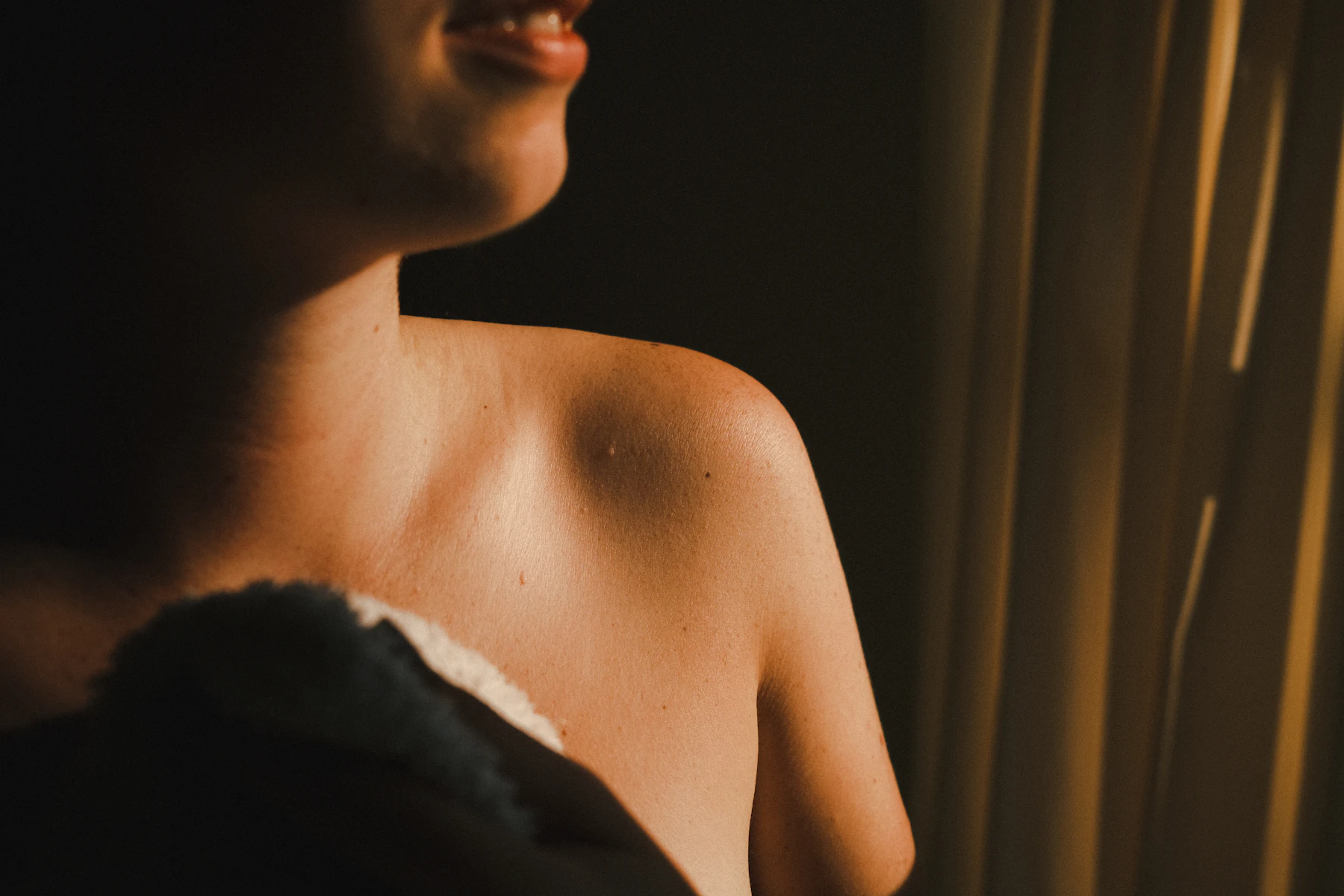 A woman's bare shoulder in warm light