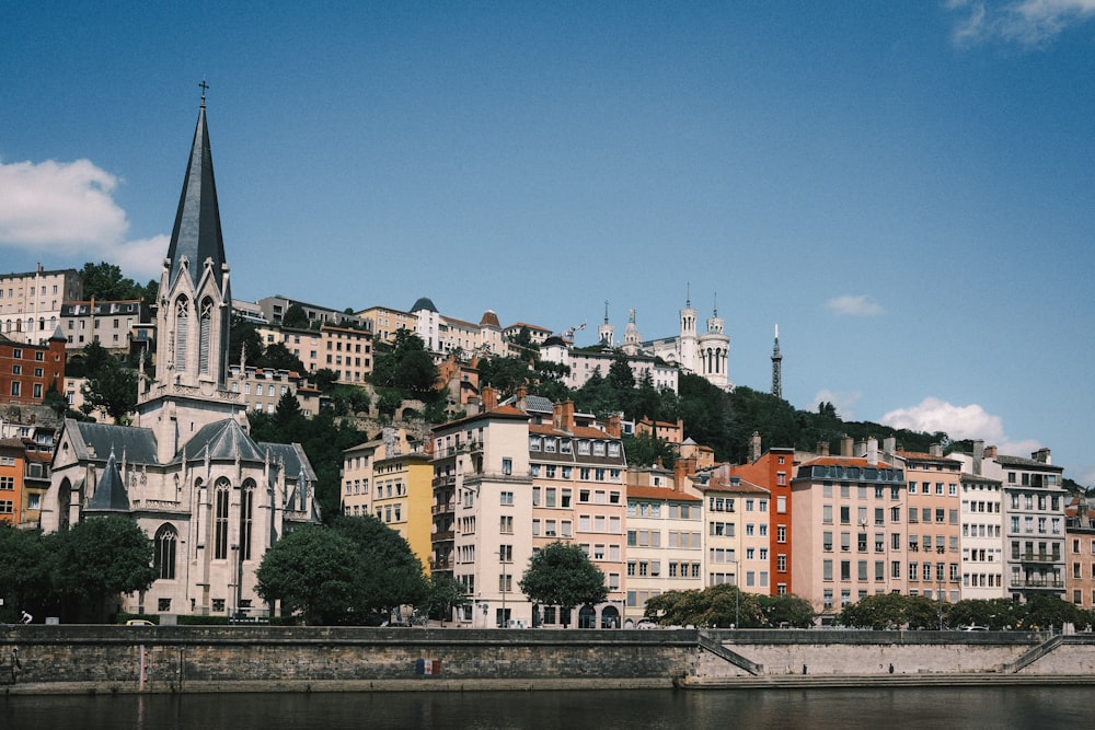 a city with a church steeple on top of a hill