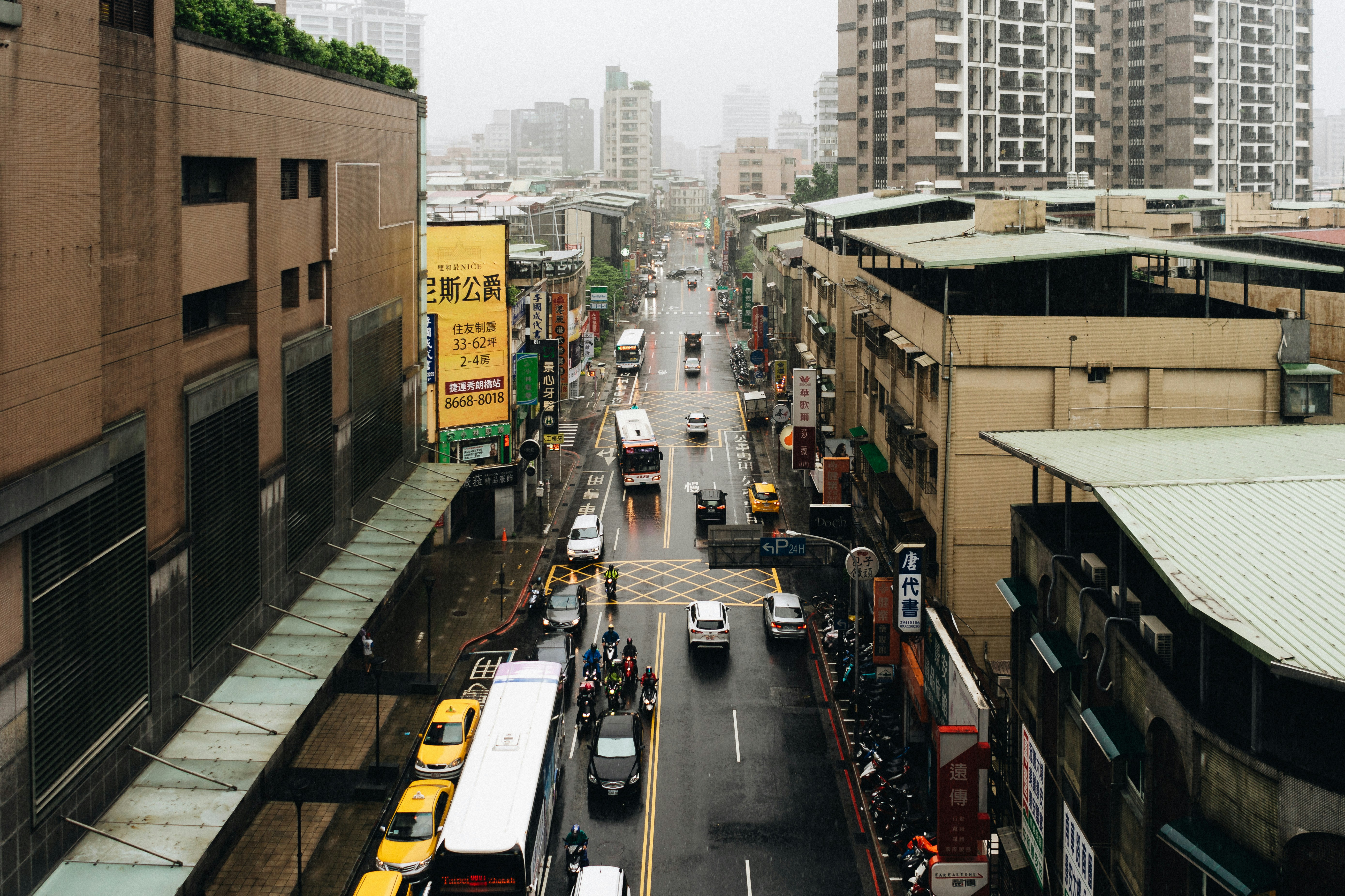 cars on road near buildings during daytime, New Taipei on a Rainy Day