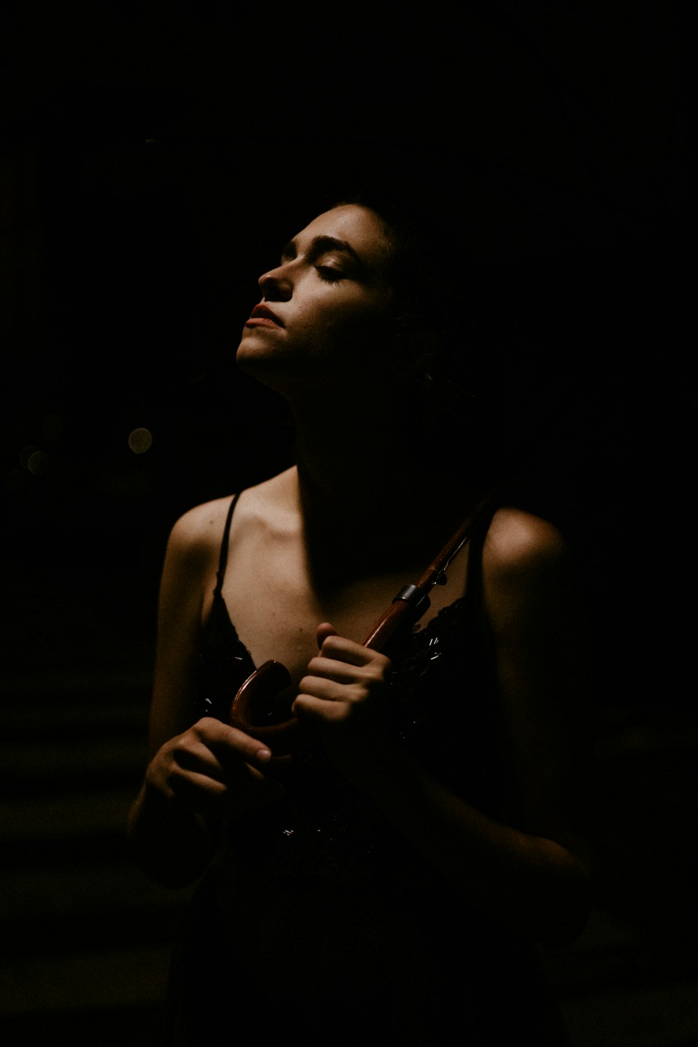 woman in white tank top holding black dslr camera