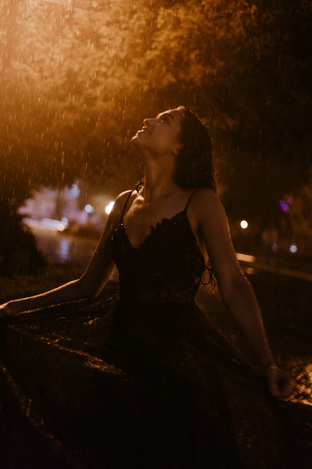 woman in black spaghetti strap dress sitting on ground