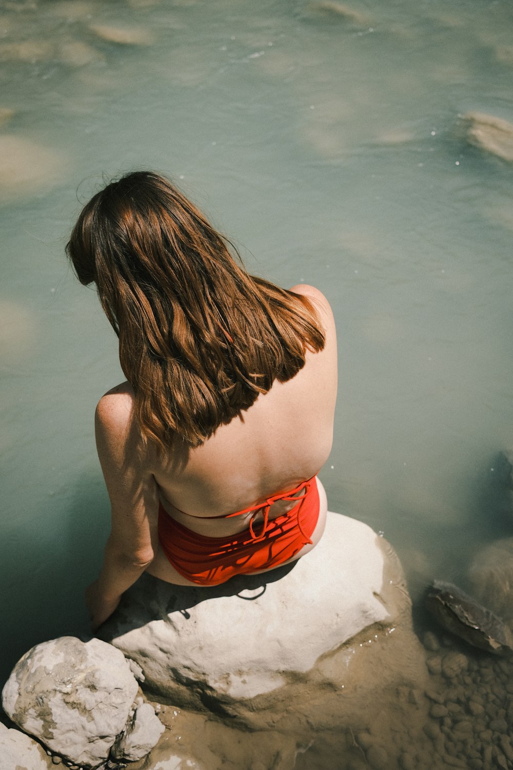 woman in red and black shorts sitting on white snow covered ground