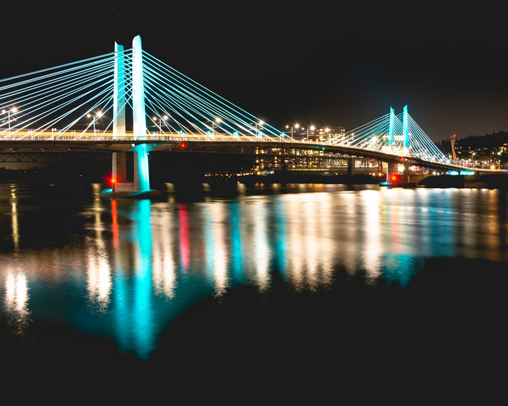 lighted bridge over water during night time