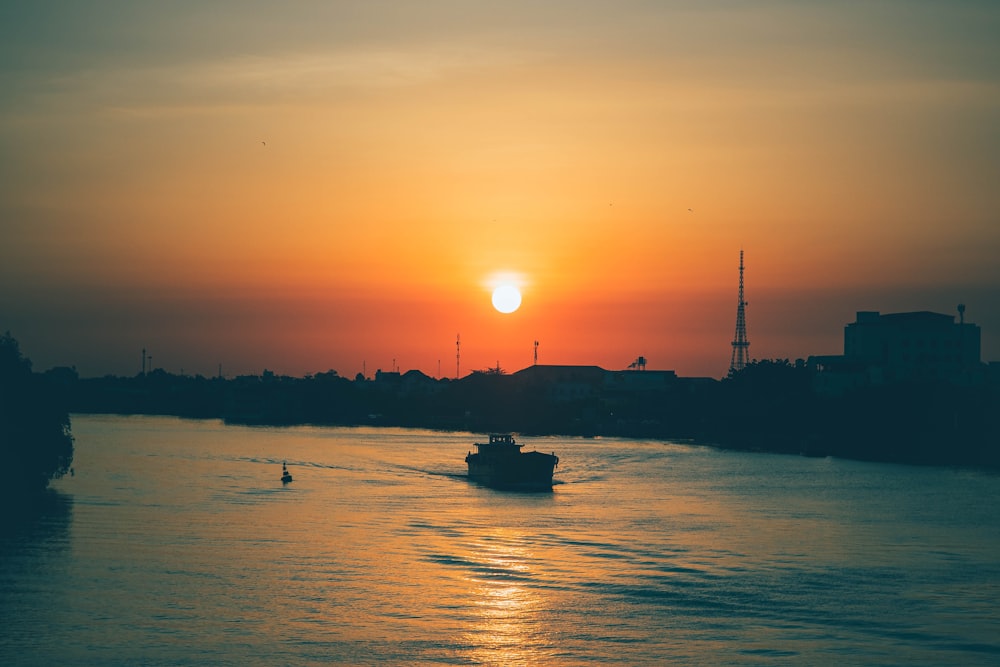 silhouette of boat on sea during sunset