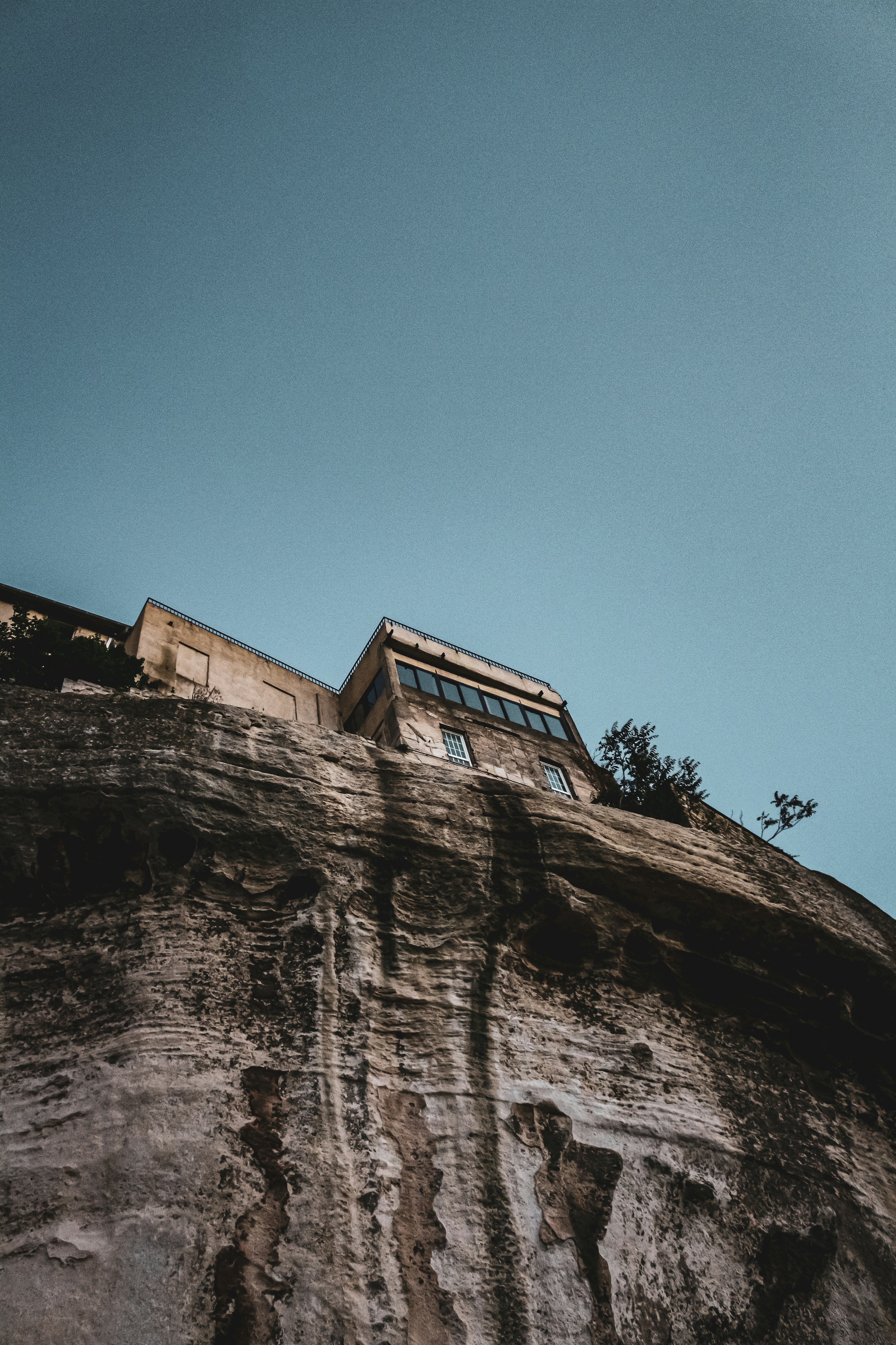 brown concrete building on brown rocky mountain under blue sky during daytime