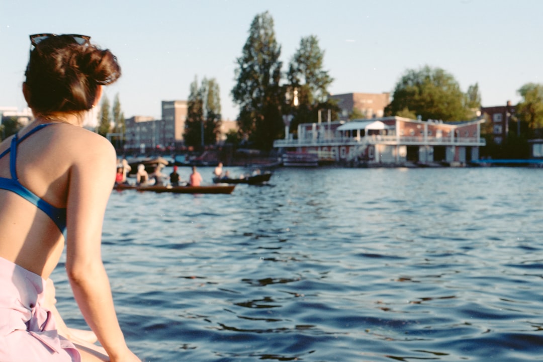 woman in black bikini top standing near body of water during daytime