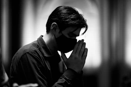 man in black leather jacket covering his face
