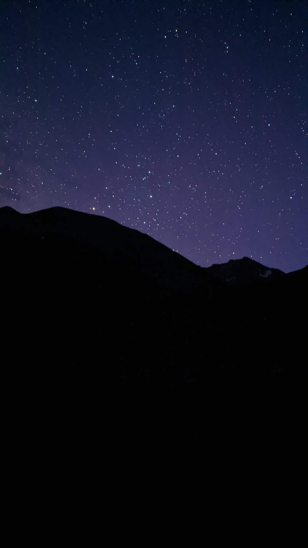 silhouette of mountain under starry night