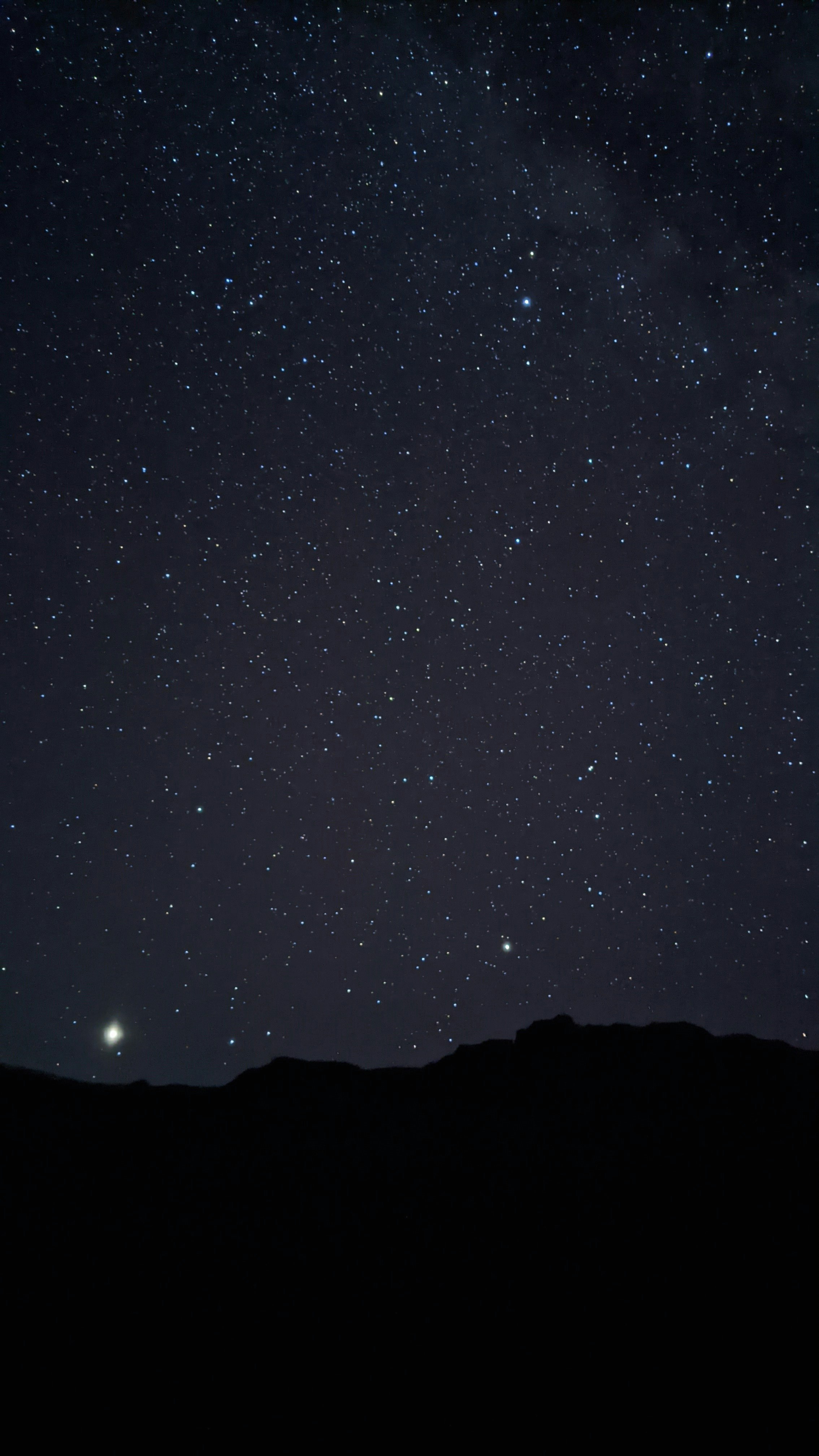 silhouette of mountain under starry night