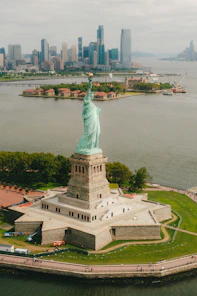 statue of liberty near body of water during daytime