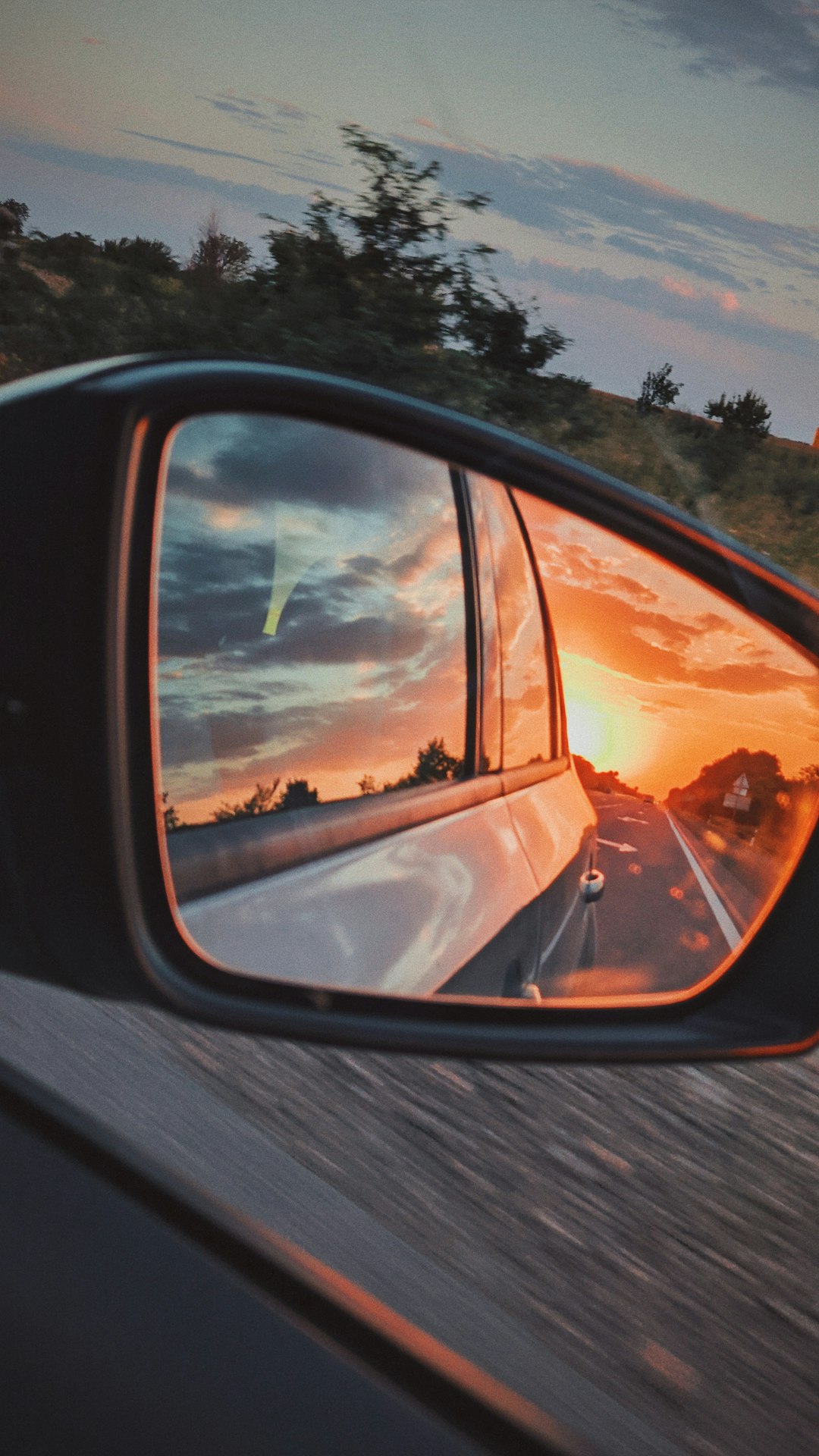car side mirror showing sunset