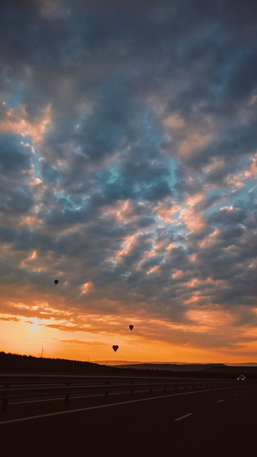 silhouette of birds flying under cloudy sky during sunset