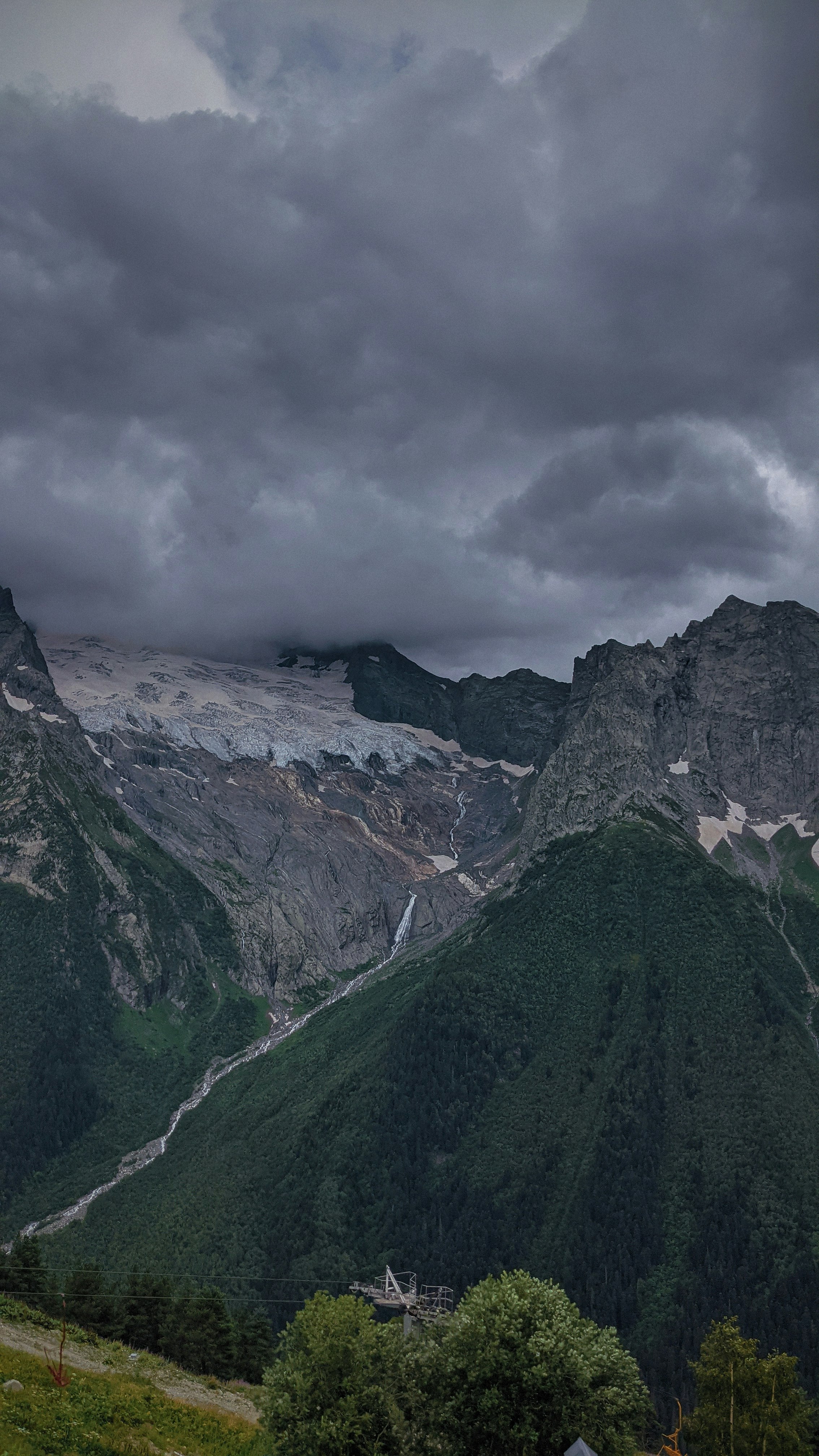 green and gray mountains under gray clouds