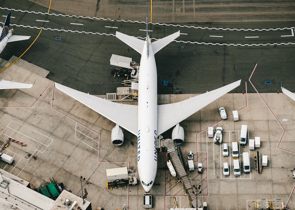 white and blue airplane on airport during daytime