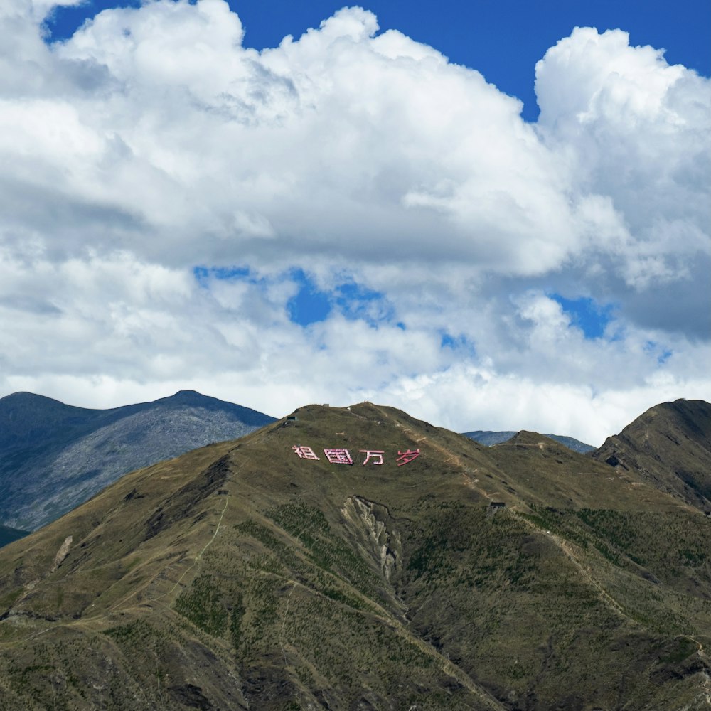 green and brown mountain under white clouds and blue sky during daytime