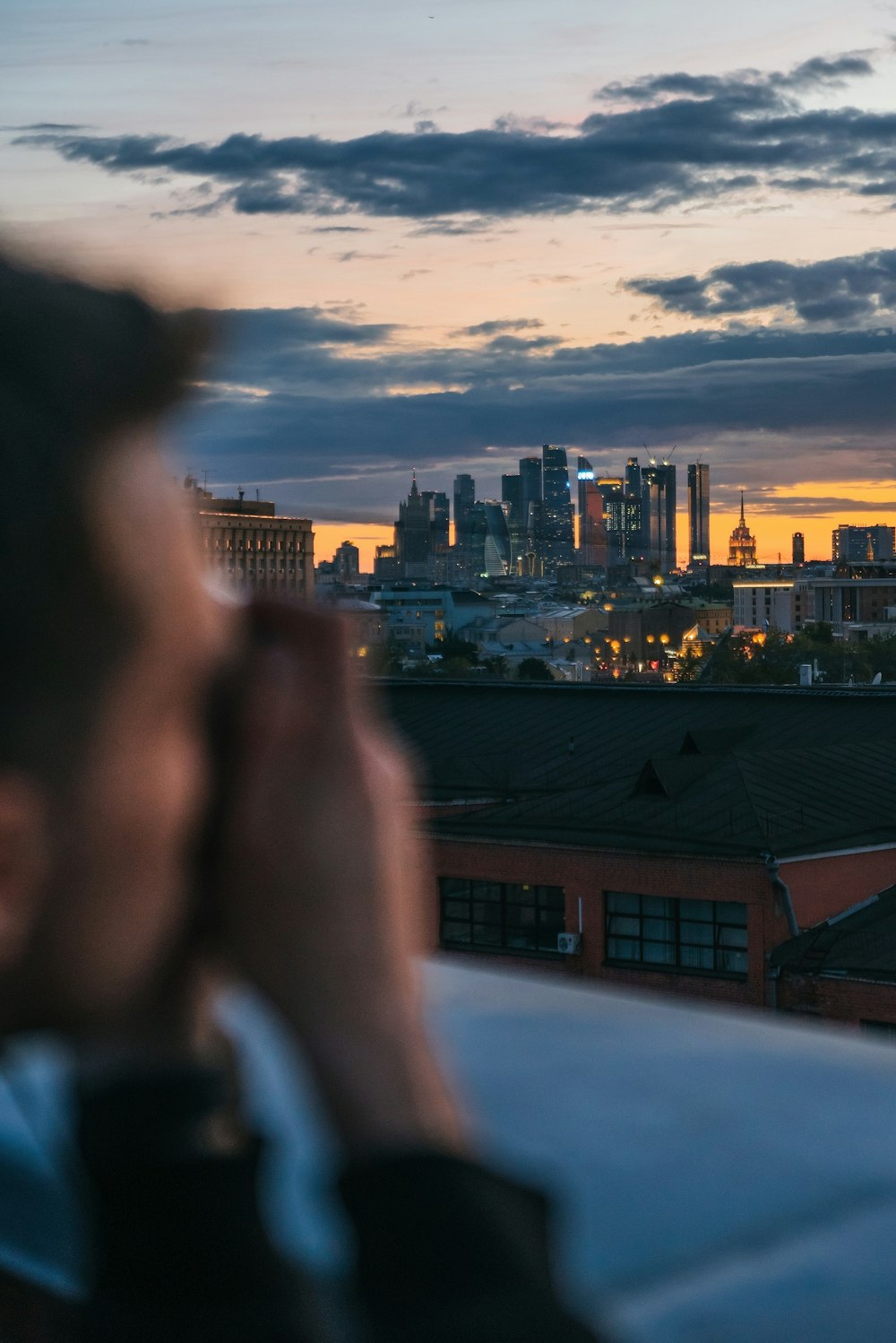 person in black sunglasses looking at the city during sunset