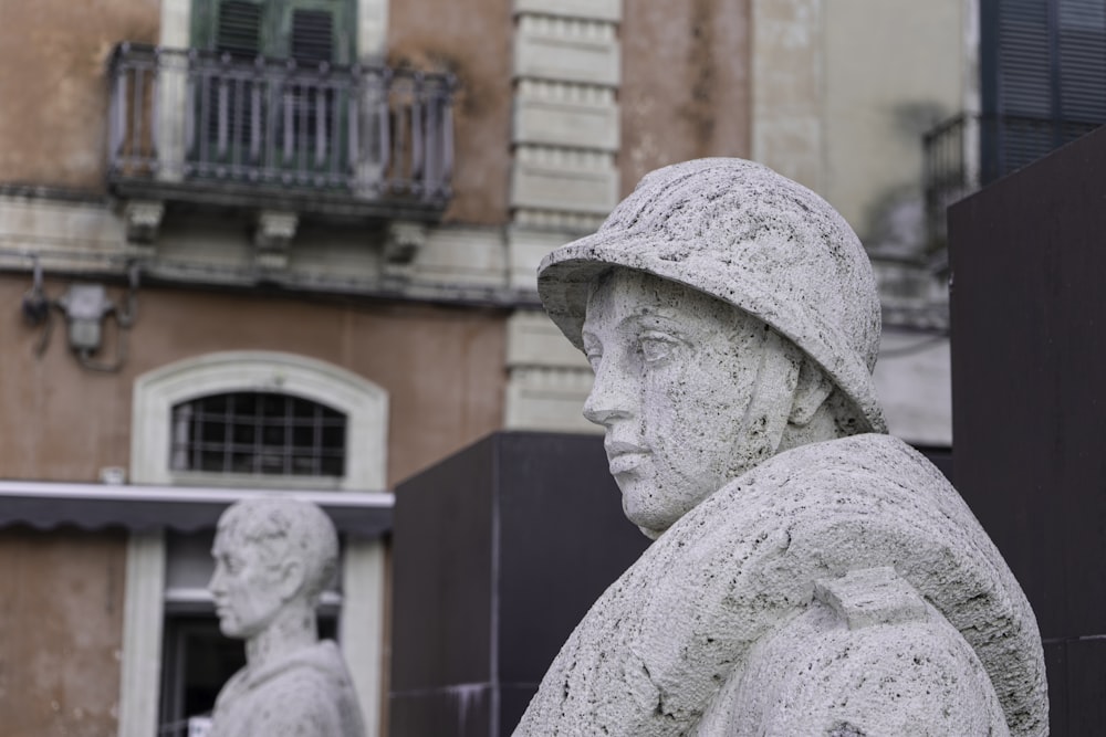 man statue in front of brown building