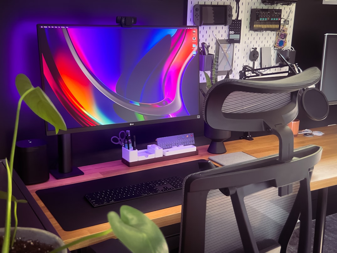 workstation with a colorfull display a gamer's chair and a wood table