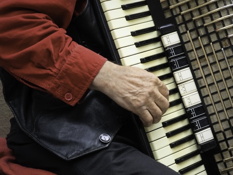 person in red shirt playing piano