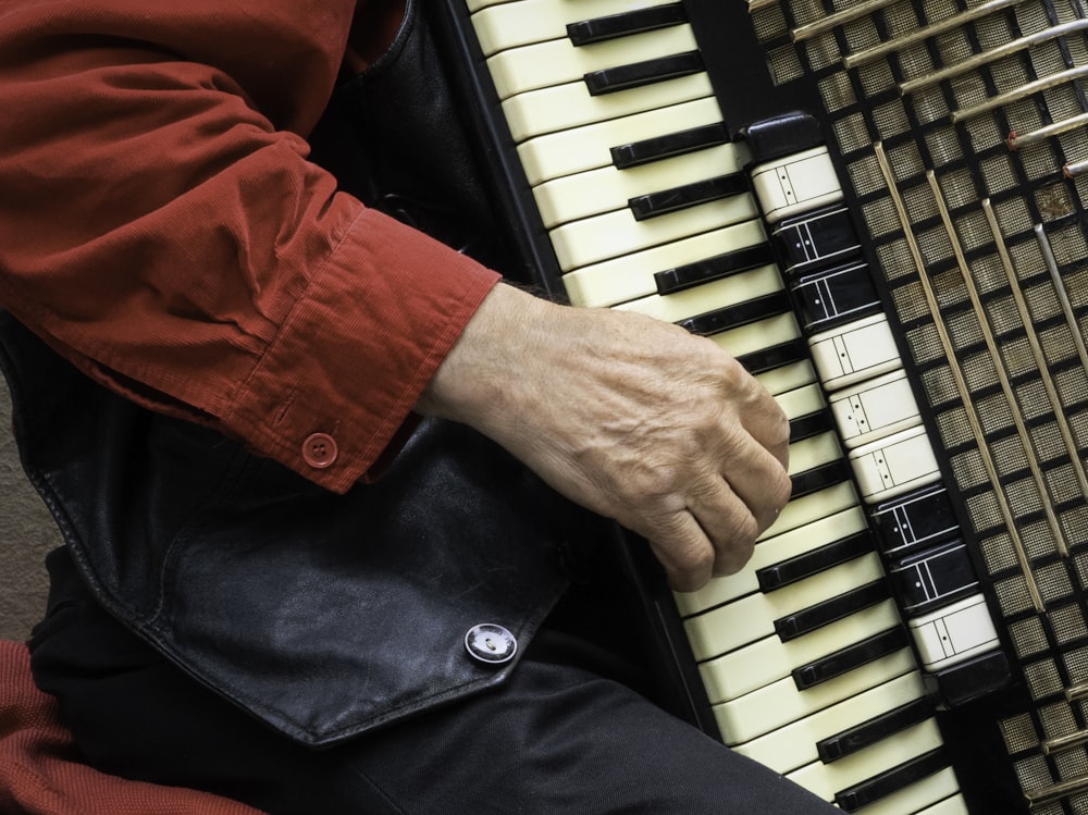 person in red shirt playing piano