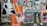 A collage of colorful street art posters on a wall, featuring a variety of graphic designs and styles. One poster has a cartoonish character emitting rainbow beams from its eyes, while another displays text about 'acid tabs'. There are printed images of people, abstract patterns, and cutouts of human figures.