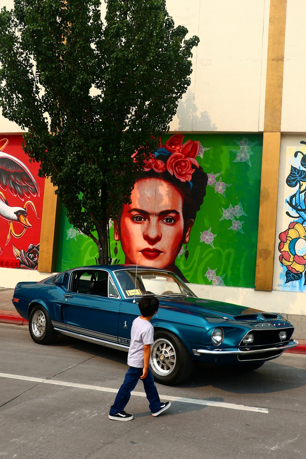 man in blue crew neck shirt standing beside black car