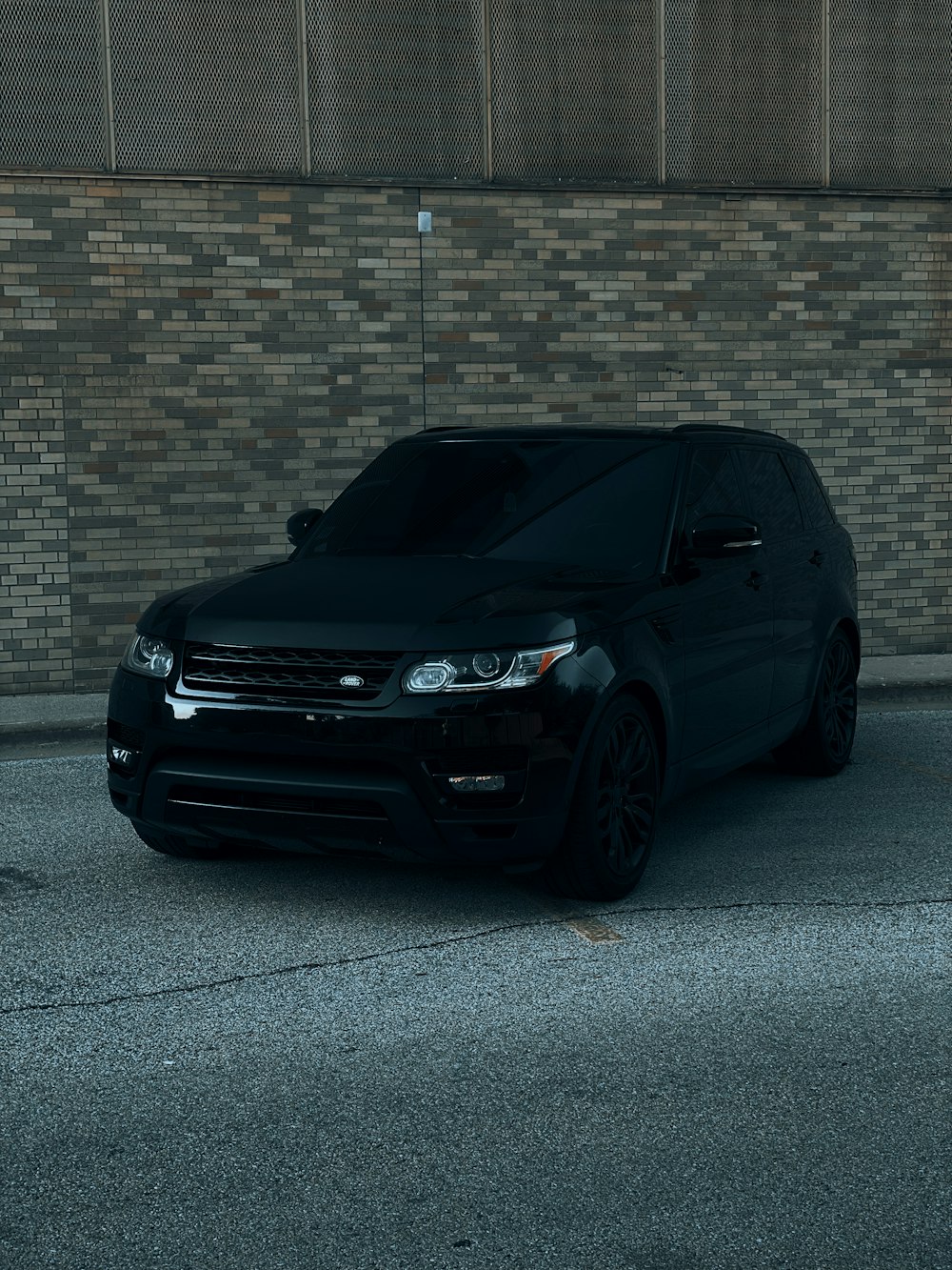 black honda car parked beside brown brick wall