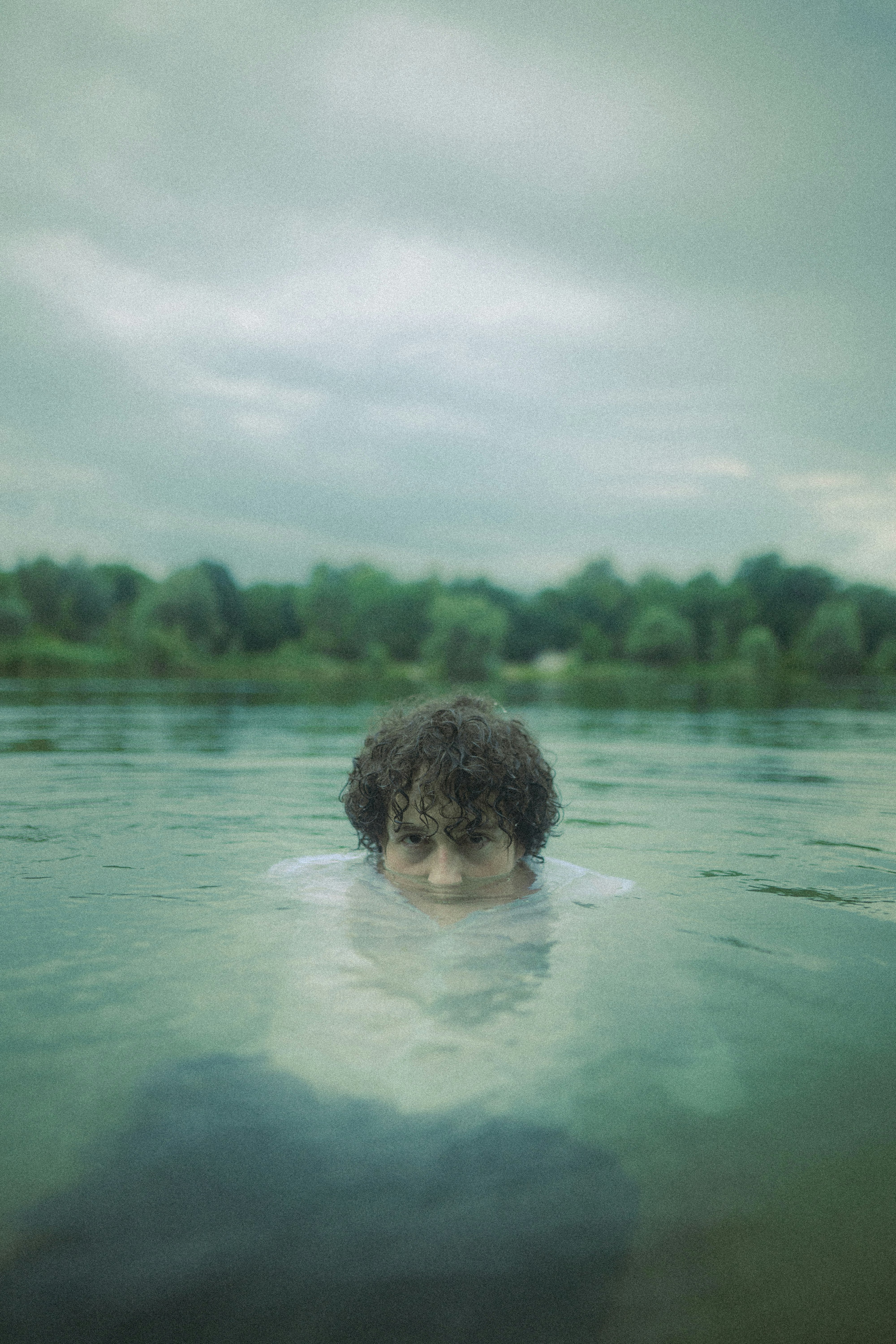boy in water under cloudy sky during daytime